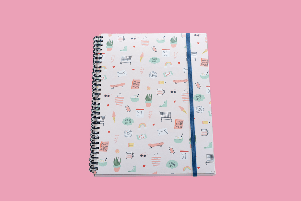 A notebook little icons of cacti, mugs, shopping carts and more on a pink background